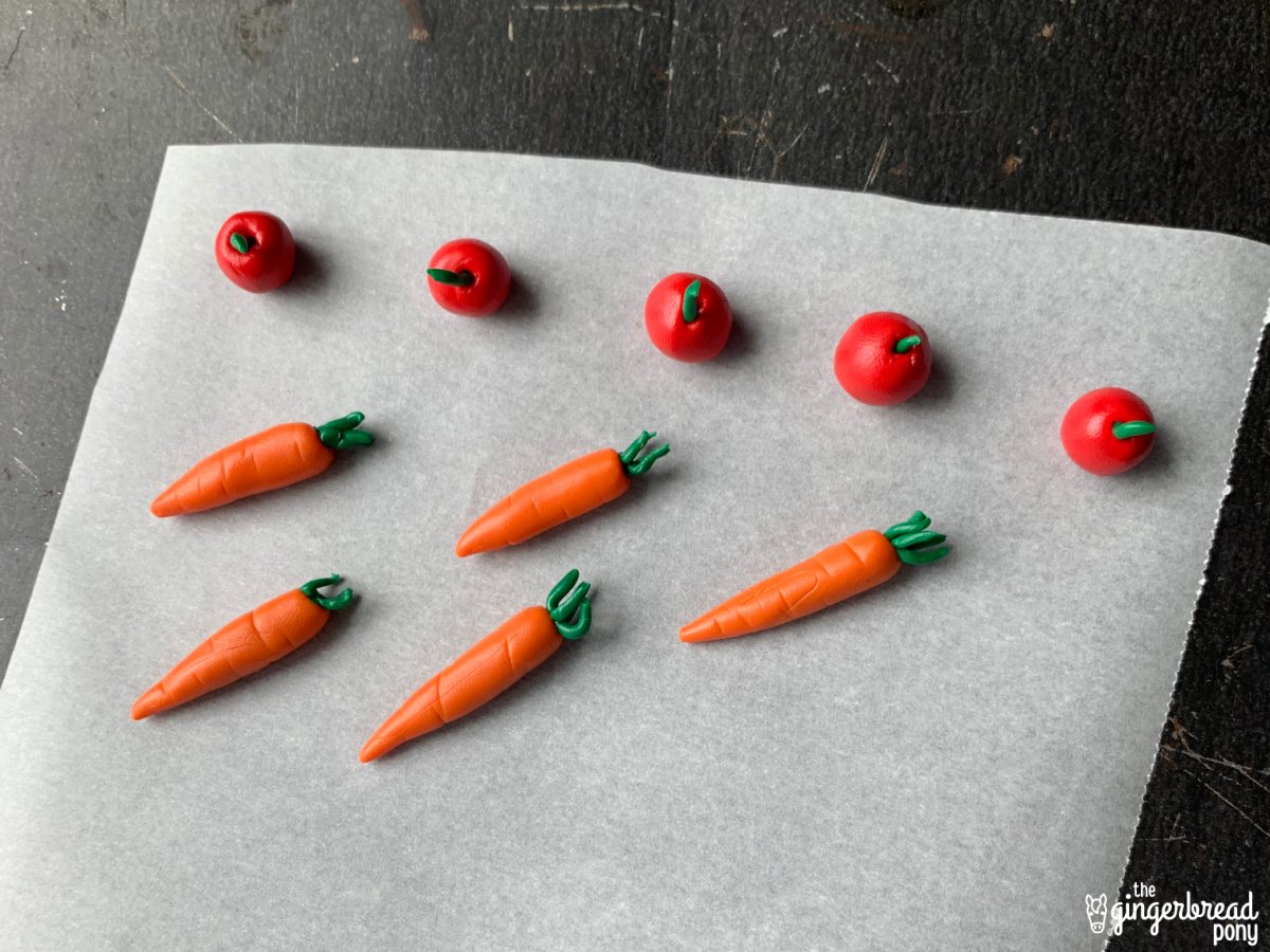 polymer clay apples and carrots on baking sheet