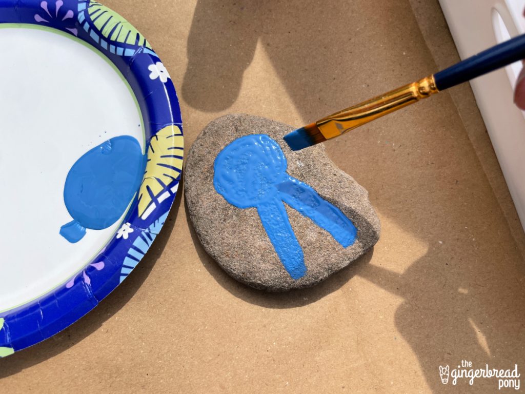 Painting blue ribbon on rock